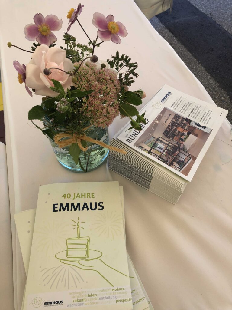 Folder und Blumenstrauß zum 40-Jahr Jubiläum der Emmausgemeinschaft St. Pölten
